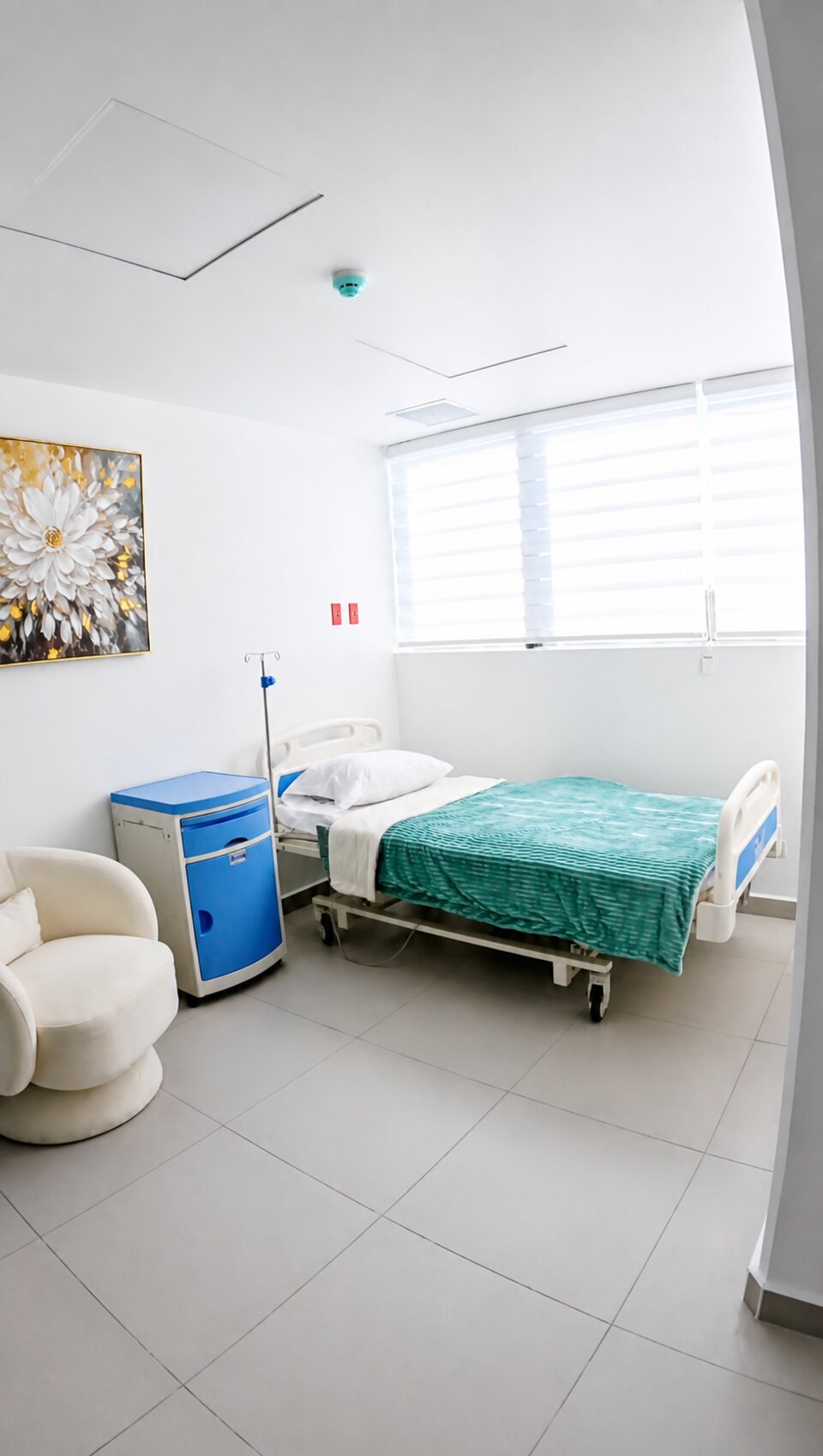 Habitación de recuperación privada con cama y sillón para acompañante